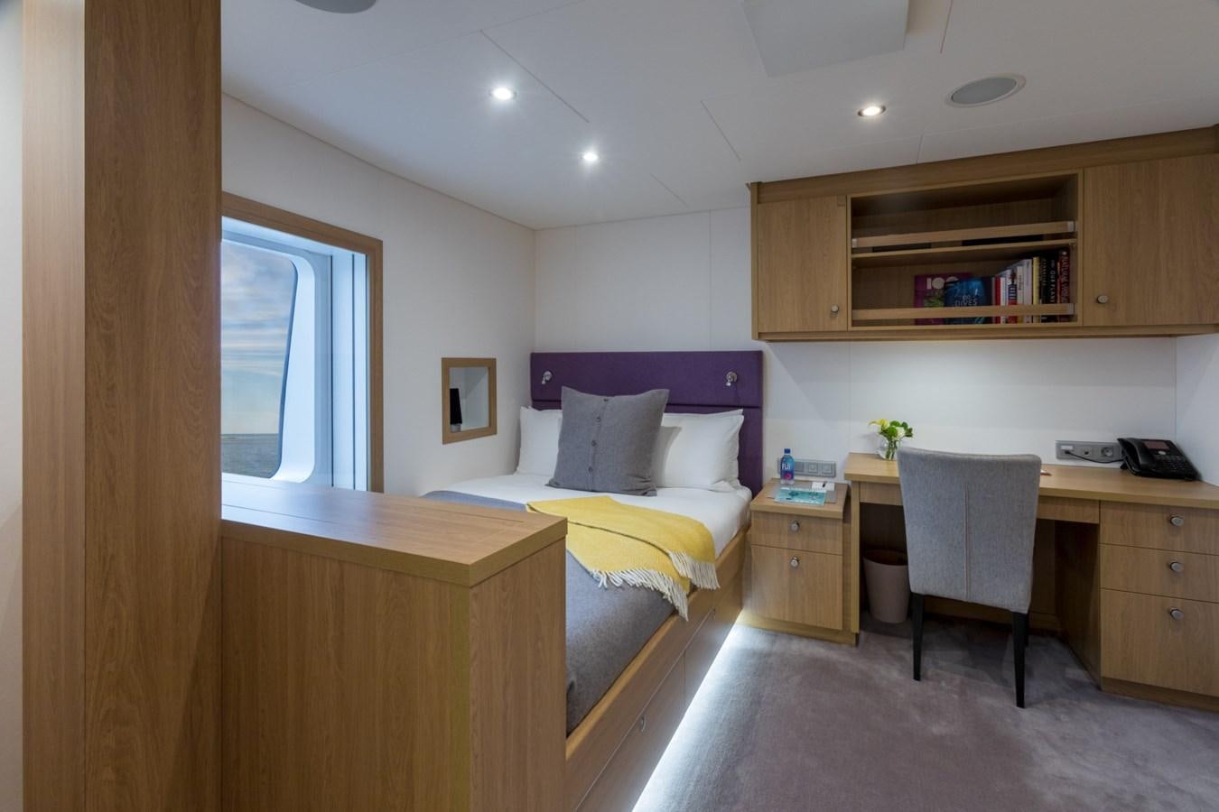 a bedroom with a desk and a bed aboard GAME CHANGER Yacht for Sale
