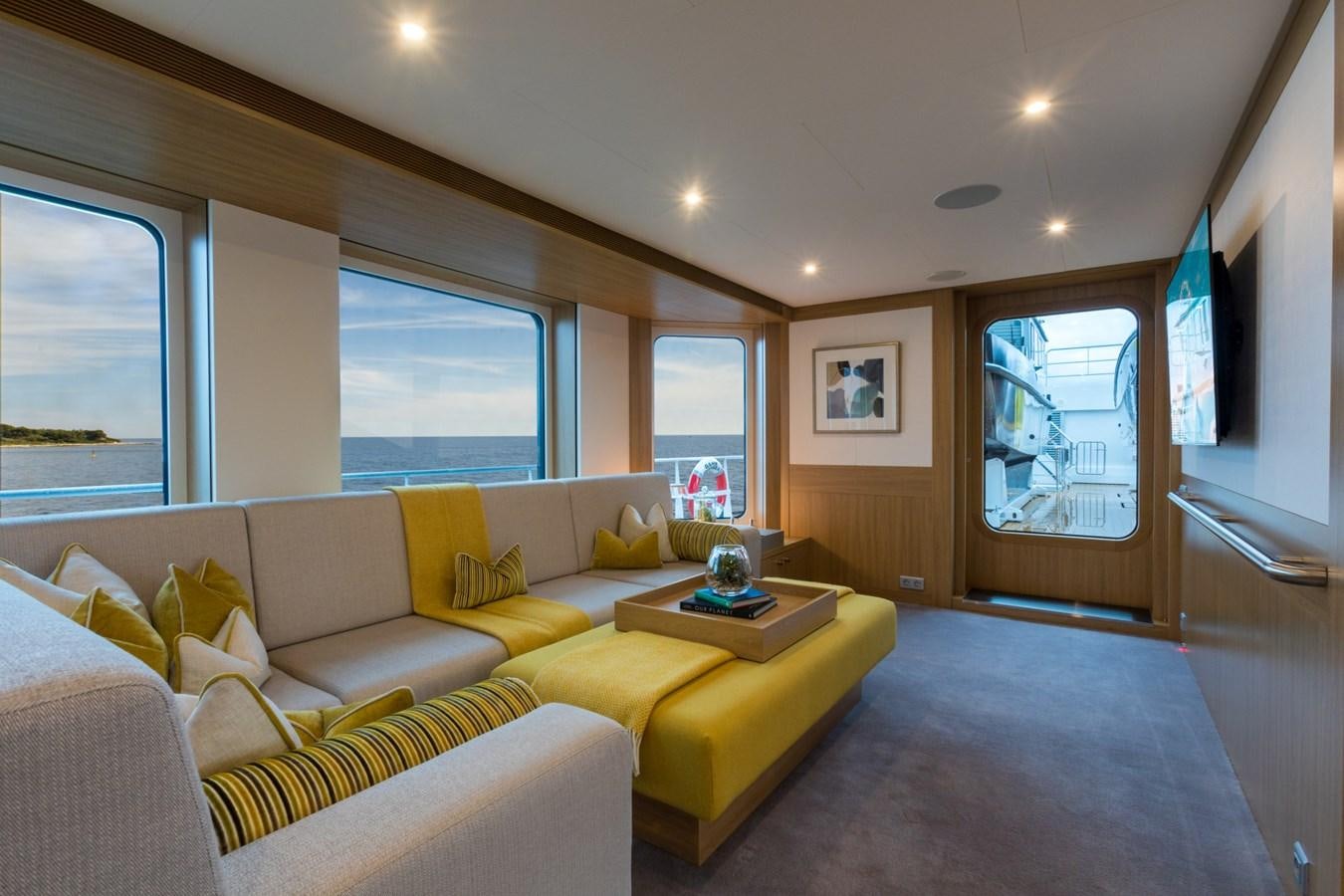a living room with yellow couches aboard GAME CHANGER Yacht for Sale