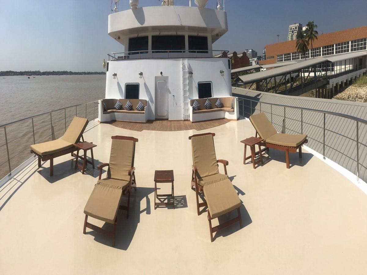 a deck with chairs and a table on it aboard ANDAMAN EXPLORER Yacht for Sale