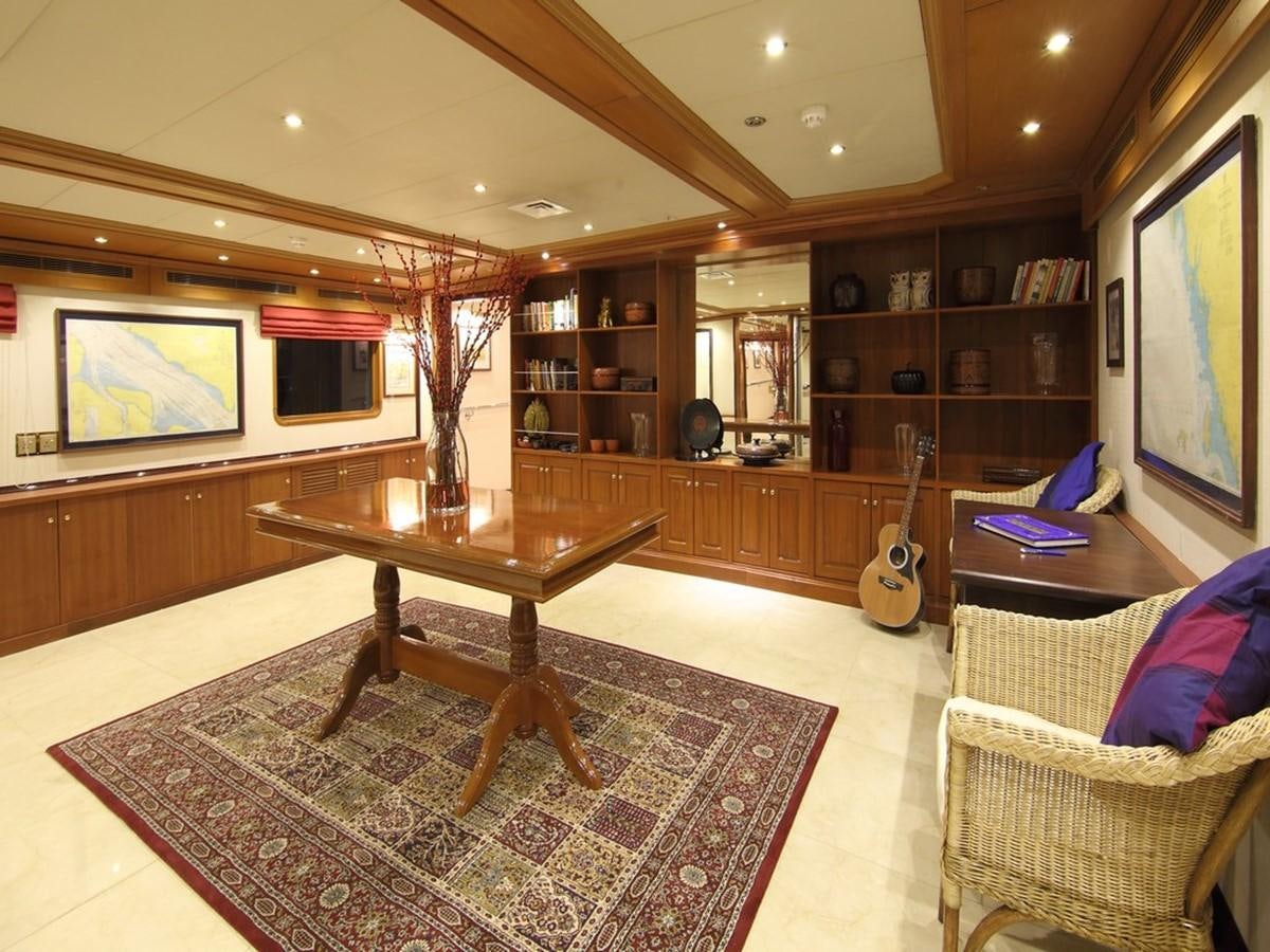 a living room with a table and couches aboard ANDAMAN EXPLORER Yacht for Sale