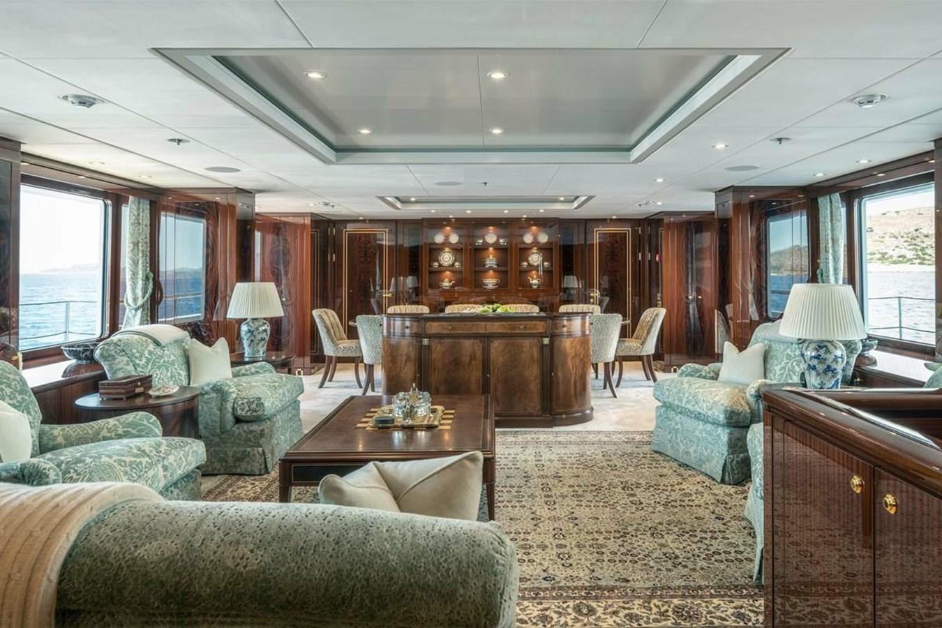 a living room with a large wood table and chairs aboard LA FAMILIA Yacht for Sale