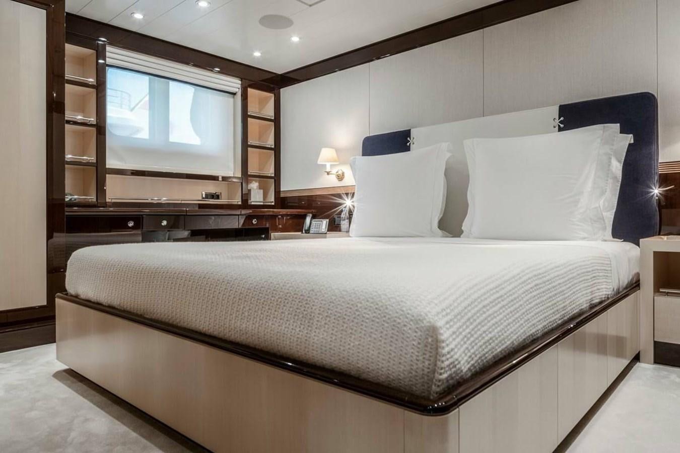a bed with a white comforter aboard LA FAMILIA Yacht for Sale