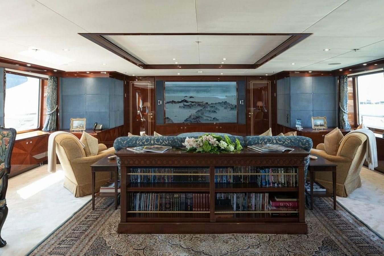 a room with a large bed and a table with chairs aboard LA FAMILIA Yacht for Sale