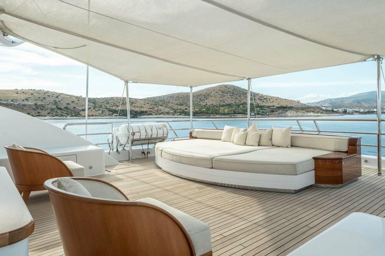 a room with a bed and chairs aboard LA FAMILIA Yacht for Sale