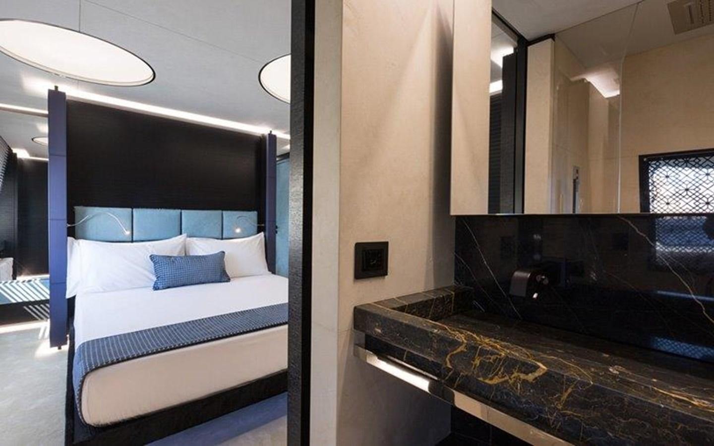 a room with a bed and a mirror aboard OCEAN PARADISE Yacht for Sale