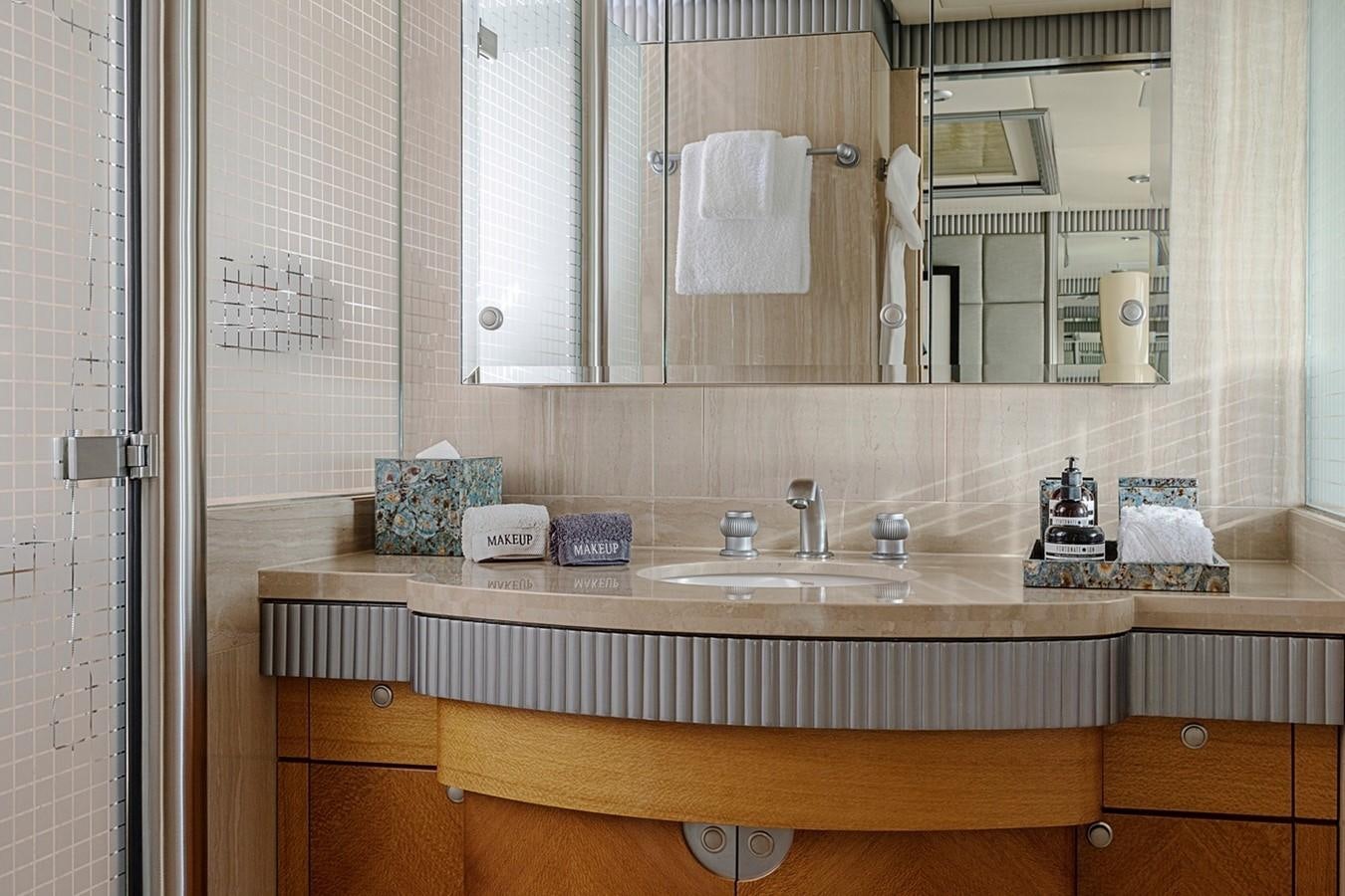 a bathroom with a countertop sink and mirror aboard FORTUNATE SUN Yacht for Sale