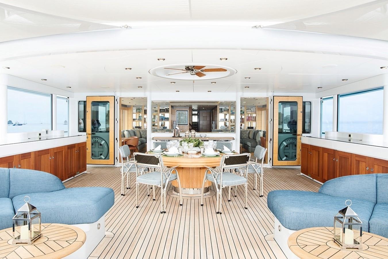 a living room with a table and chairs aboard FORTUNATE SUN Yacht for Sale