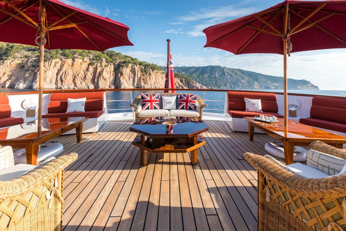 a deck with a table and chairs on it aboard ITASCA Yacht for Sale