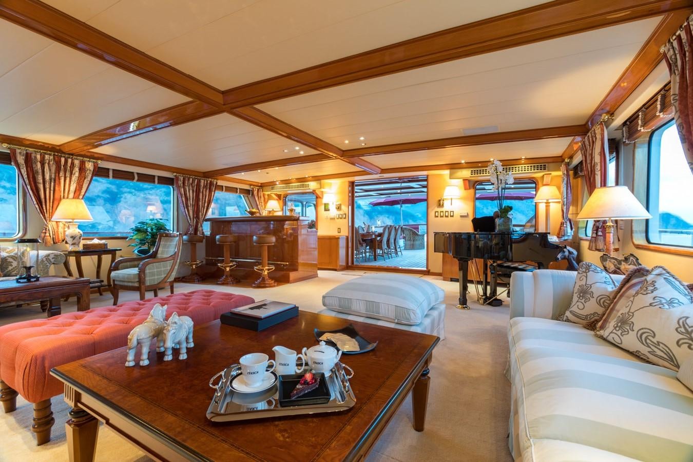 a living room with a large wood table and a large window aboard ITASCA Yacht for Sale