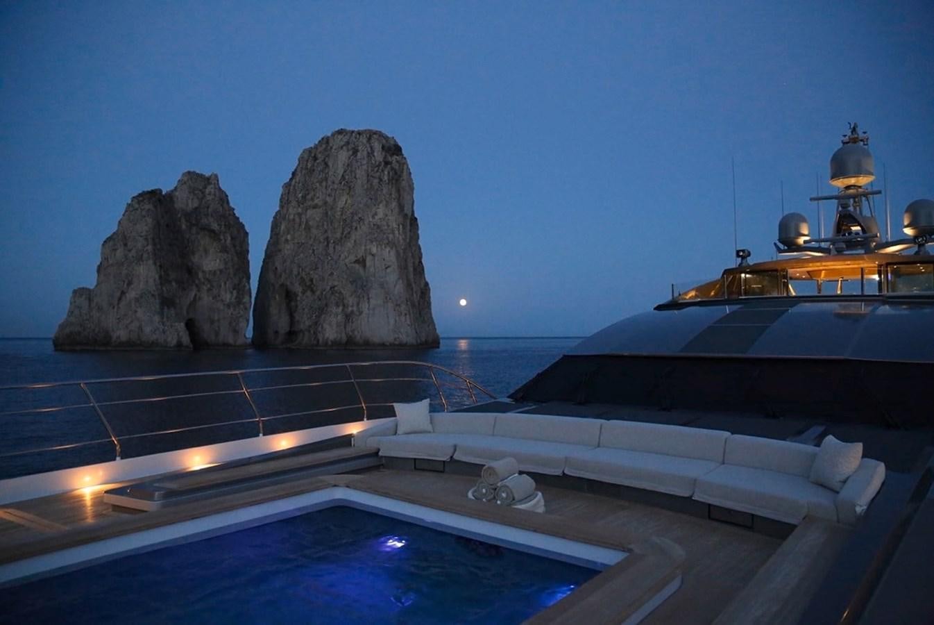 a boat on the water with Haystack Rock in the background aboard SANAM Yacht for Sale