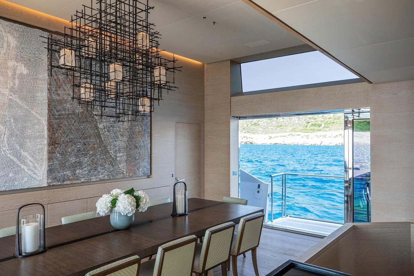 a dining table with a view of the ocean aboard SANAM Yacht for Sale
