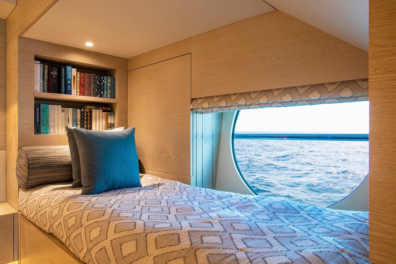 a bed with a blue and white comforter and pillows aboard SANAM Yacht for Sale