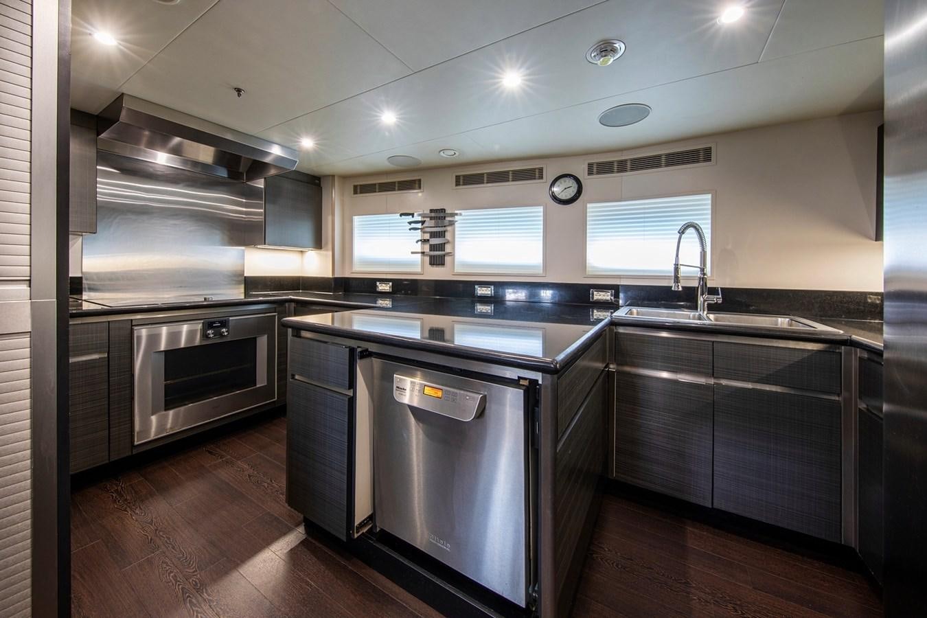 a kitchen with black appliances aboard SANAM Yacht for Sale