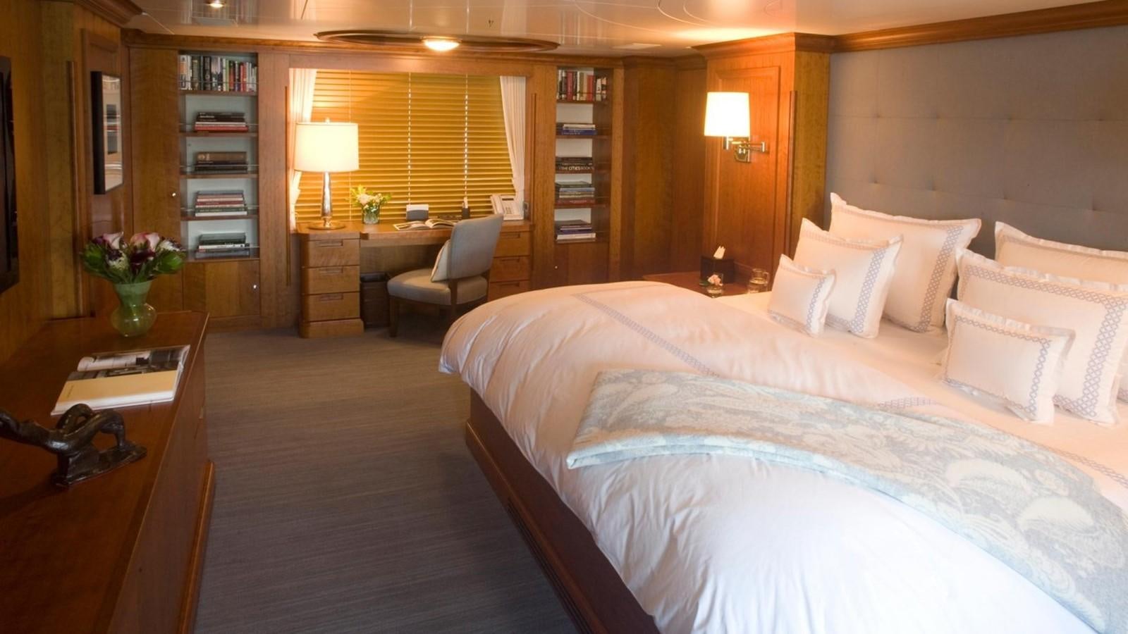 a bedroom with a bed and a desk aboard HADIA Yacht for Sale