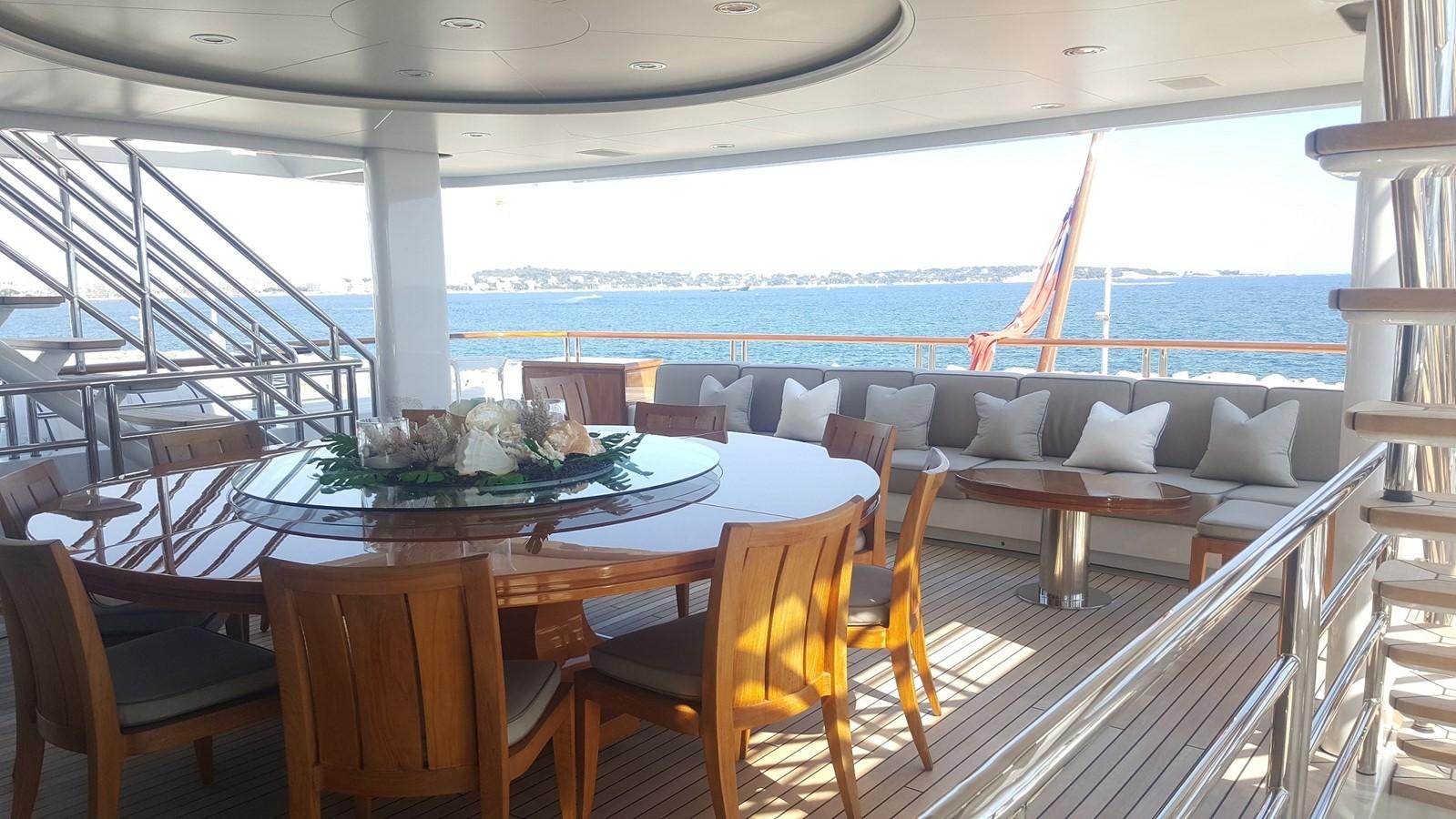 a dining table on a balcony overlooking the ocean aboard HADIA Yacht for Sale