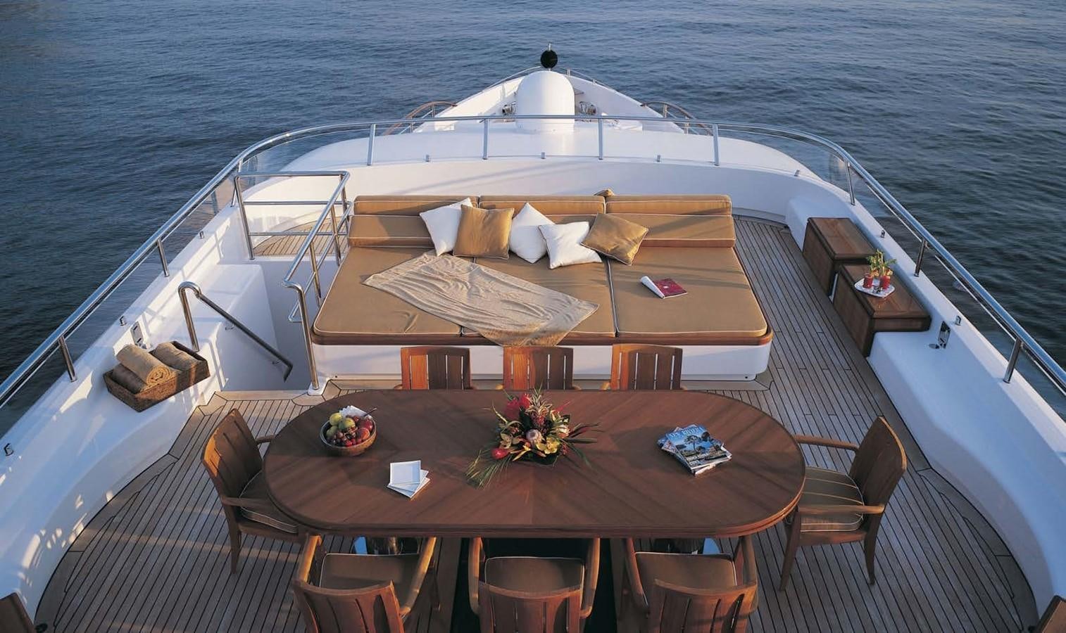 a deck with a table and chairs on it aboard HADIA Yacht for Sale