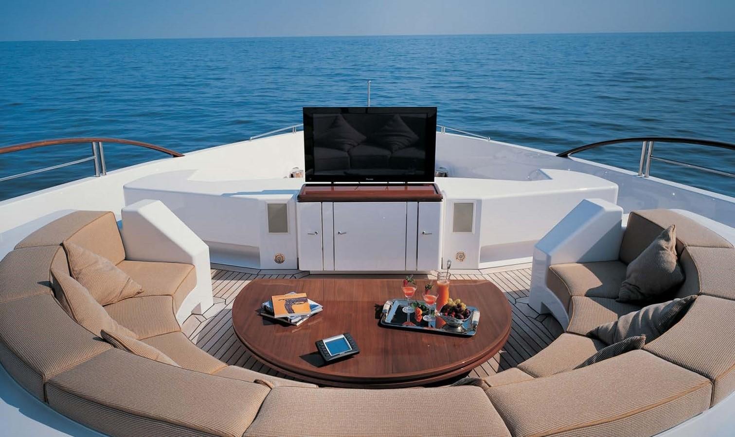 a living room with a large sofa and a table with a laptop on it aboard HADIA Yacht for Sale