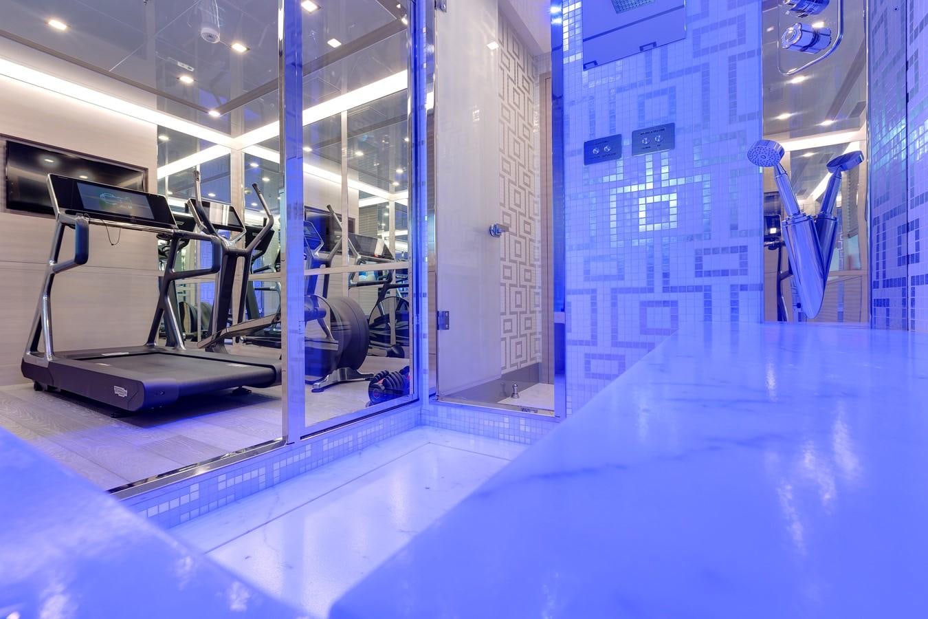 a large room with a large glass wall and a table with chairs aboard APRICITY Yacht for Sale