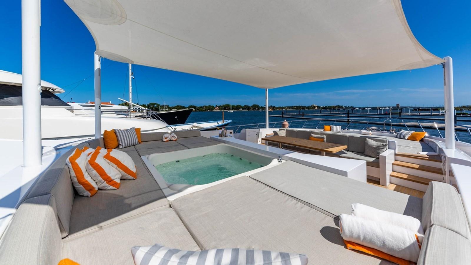 a lounge area with a pool and lounge chairs on it aboard APRICITY Yacht for Sale