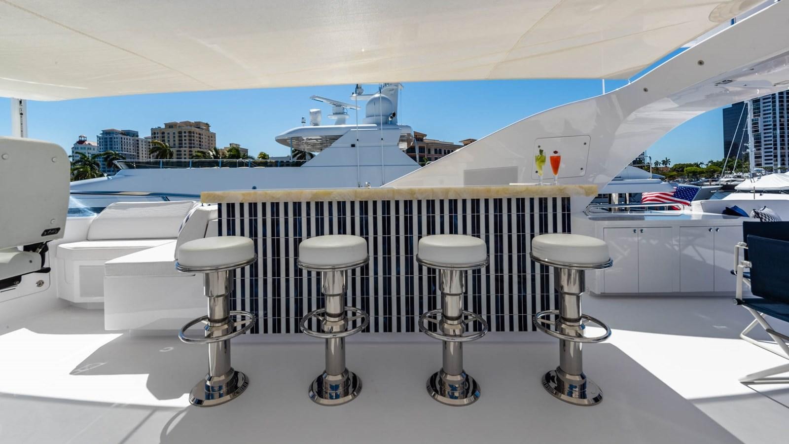 a row of stools on a white surface in front of a window aboard APRICITY Yacht for Sale
