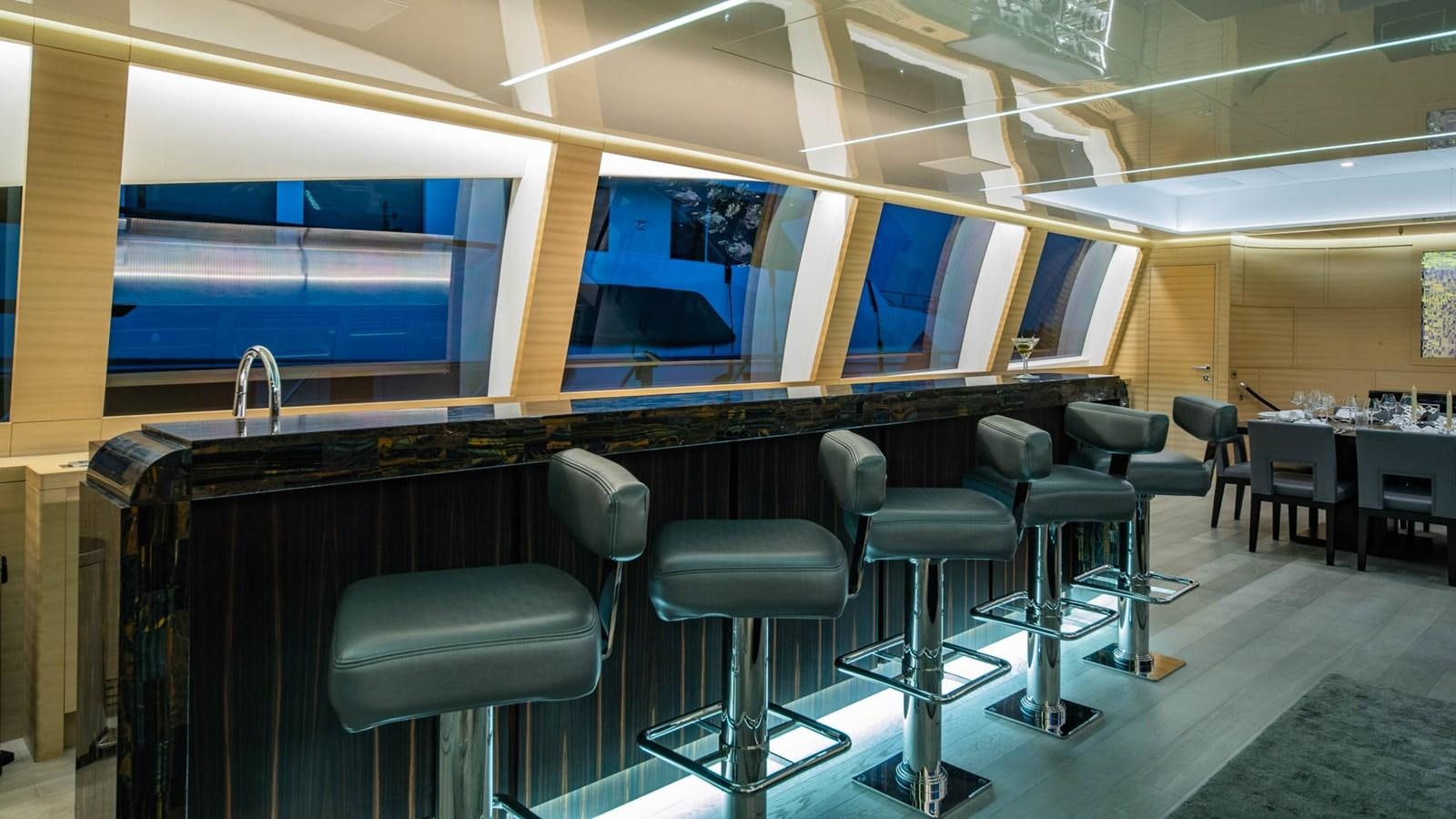 a room with stools and a tv aboard APRICITY Yacht for Sale