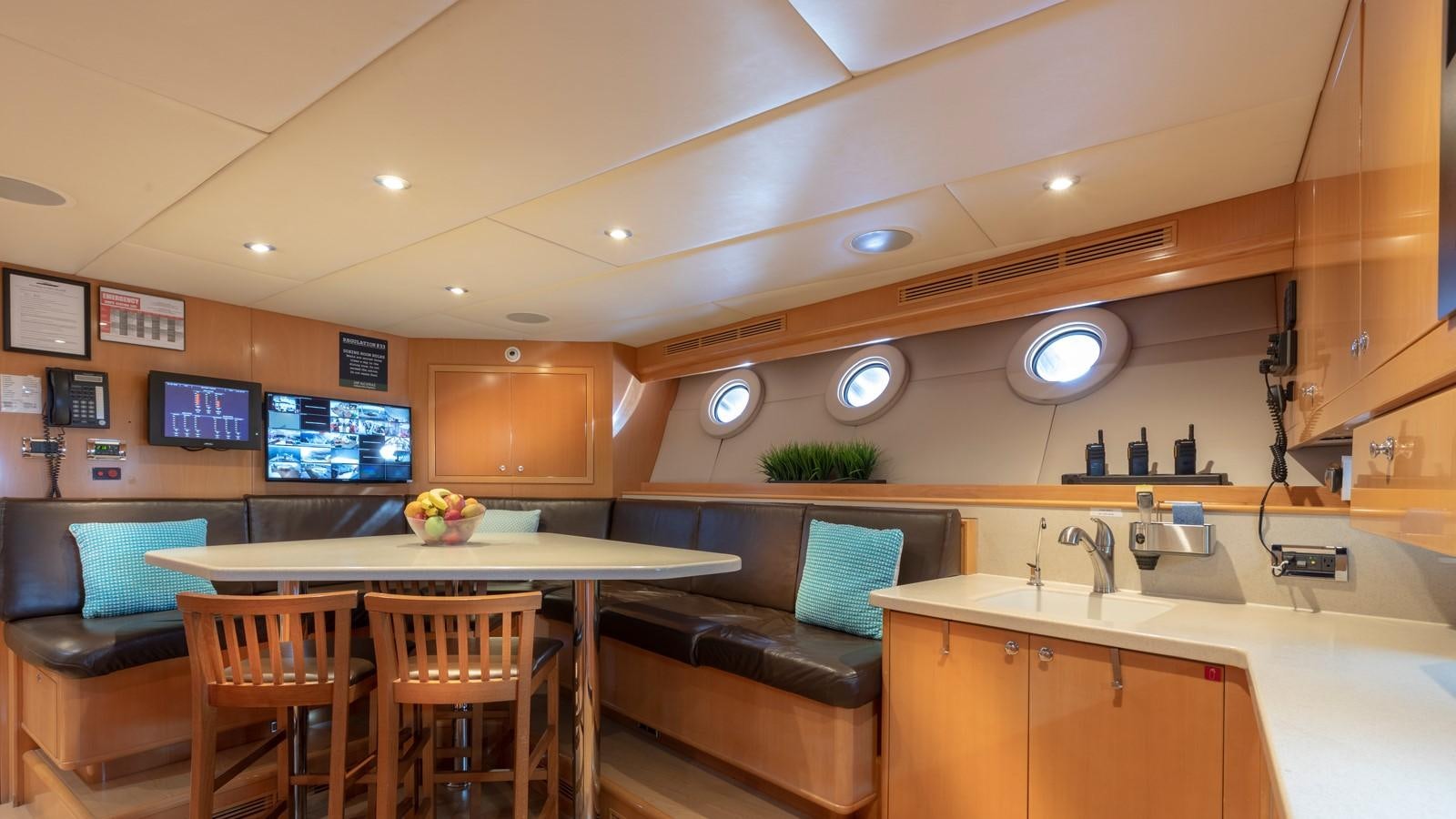 a kitchen with a bar and a table aboard GLAZE Yacht for Sale
