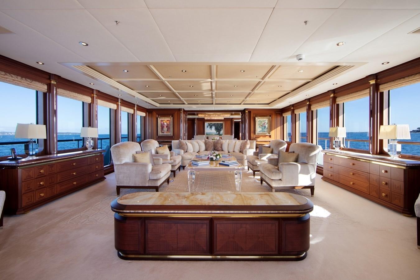 a living room with a large wood table and a large window aboard OLMIDA Yacht for Sale