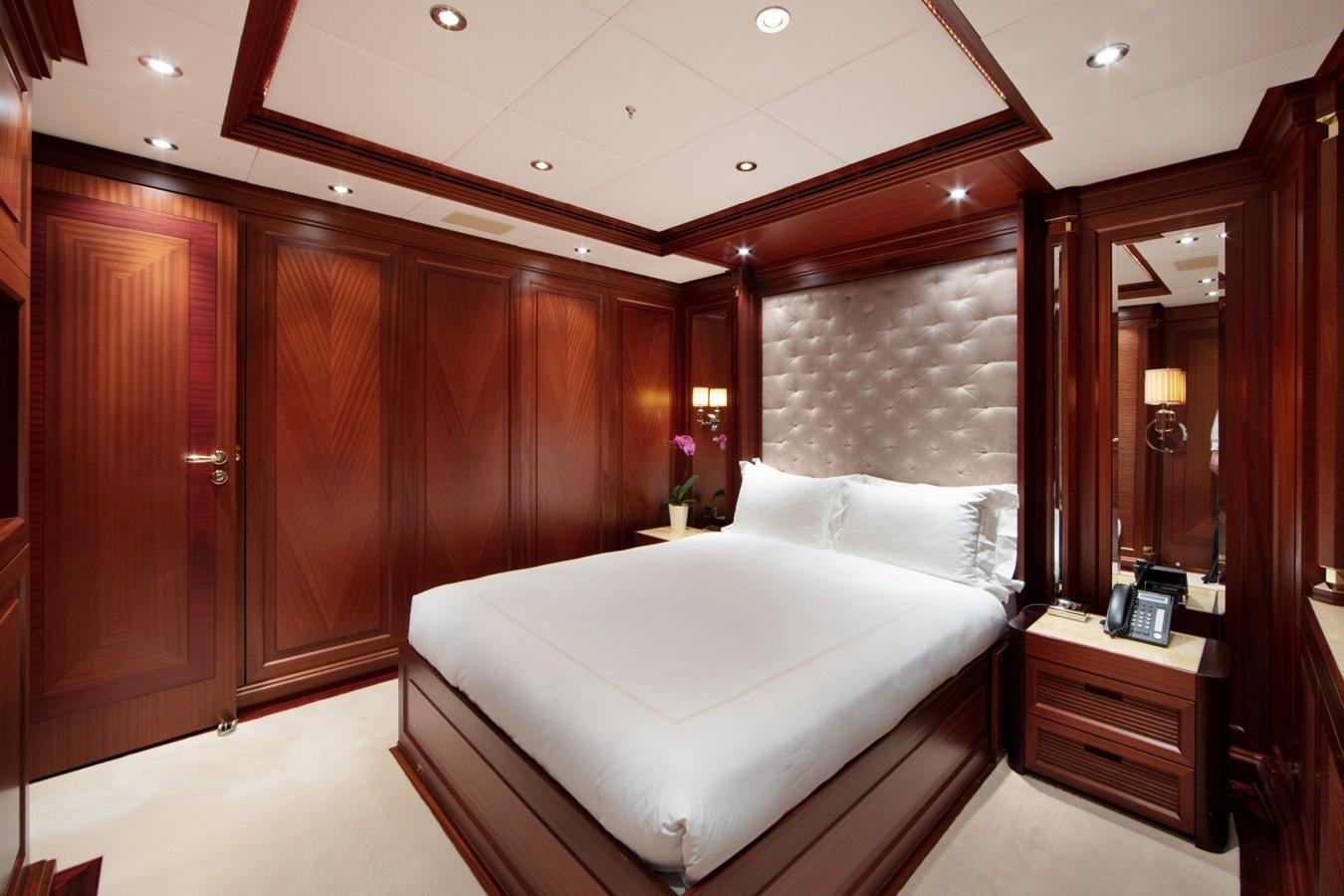 a bedroom with a bed and a mirror aboard OLMIDA Yacht for Sale