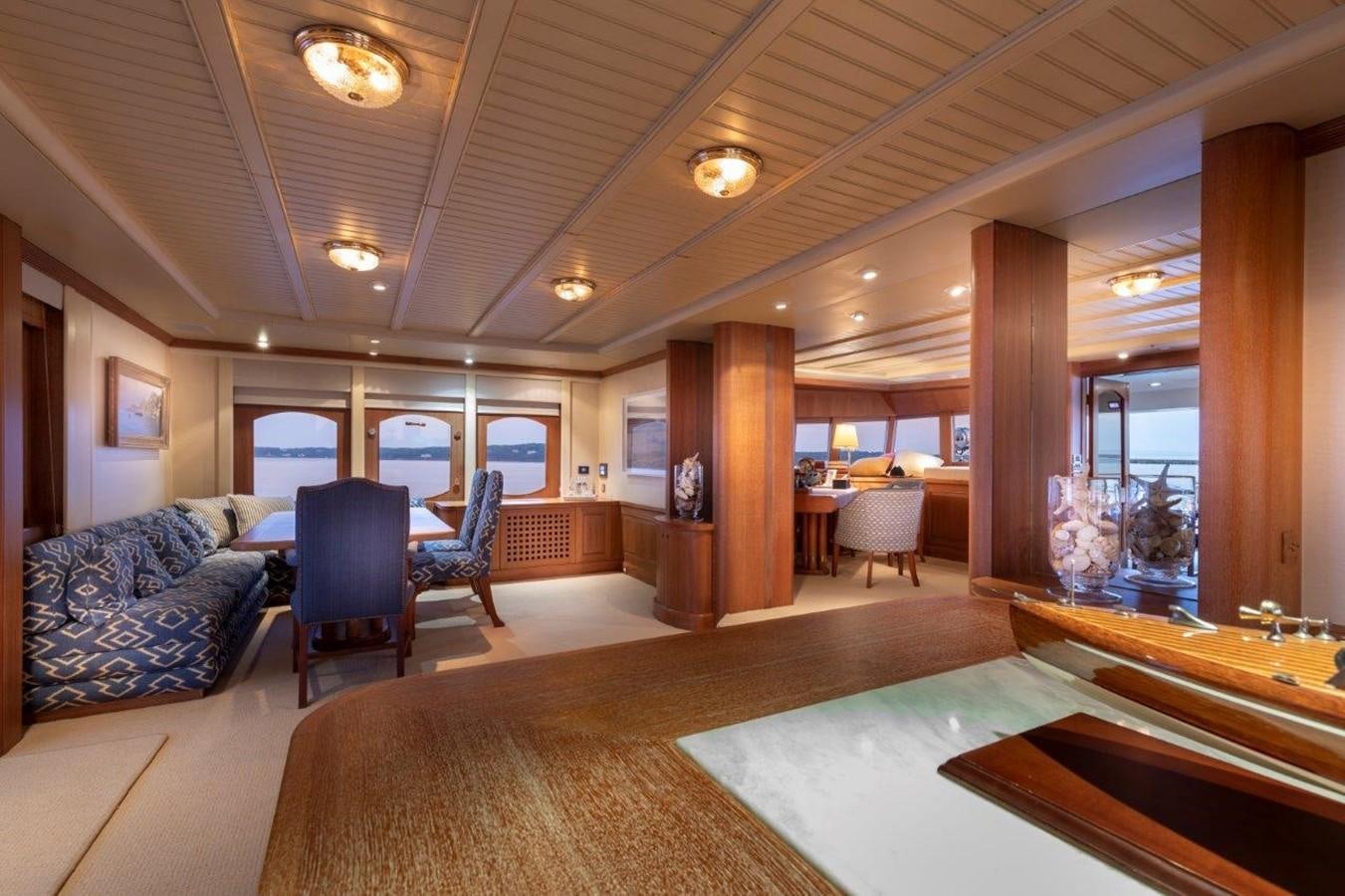 a large living room with a large wood table and chairs aboard GLACIAL BEAR Yacht for Sale