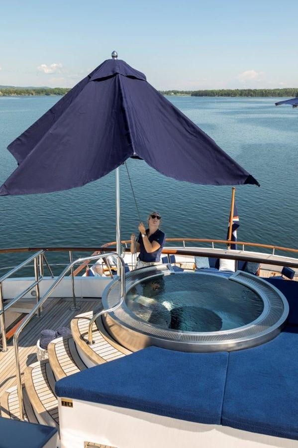 a person sitting on a boat under an umbrella aboard GLACIAL BEAR Yacht for Sale