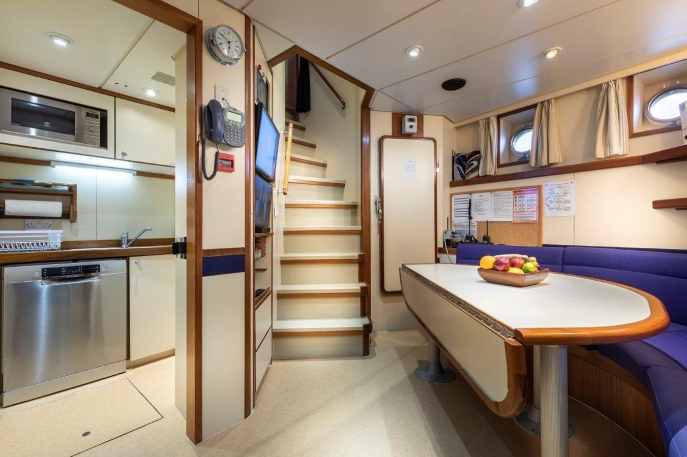 a kitchen with a table and a staircase aboard GLACIAL BEAR Yacht for Sale