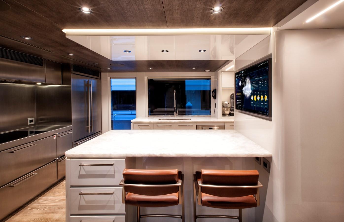 a kitchen with a counter and chairs aboard PEPPER XIII Yacht for Sale