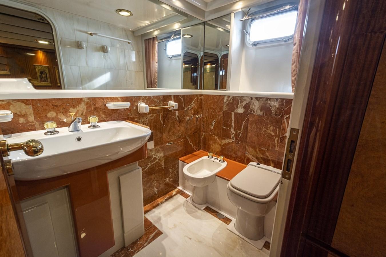 a bathroom with a sink toilet and a mirror aboard ELECTA Yacht for Sale