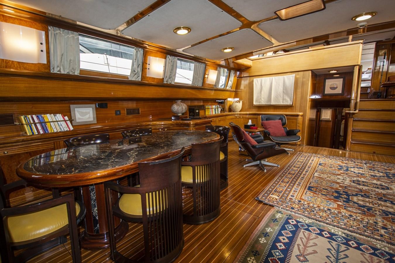 a room with a table chairs and a bench aboard ELECTA Yacht for Sale
