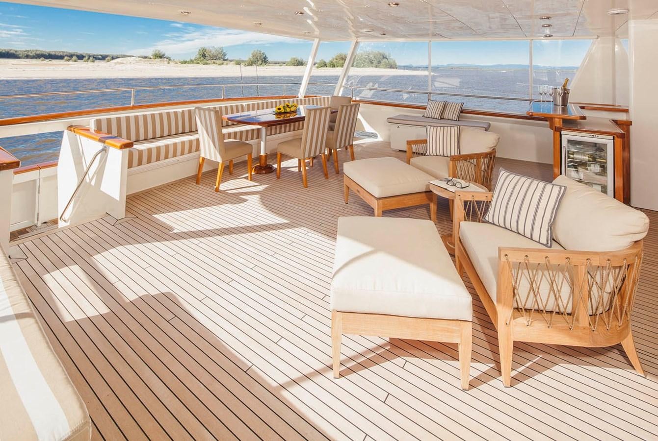 a deck with chairs and tables on it aboard SILENT WORLD II Yacht for Sale