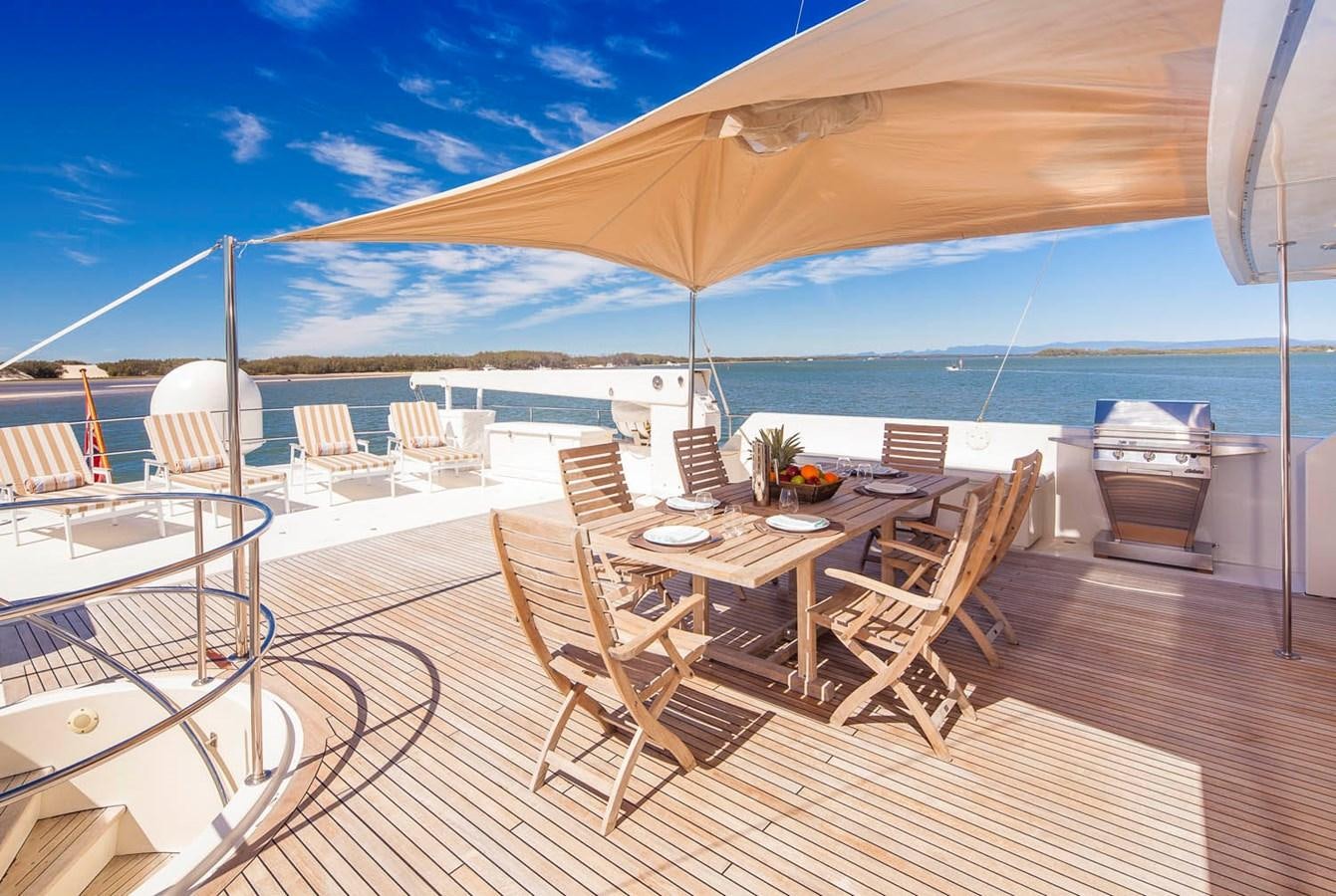 a patio with a table and chairs on it aboard SILENT WORLD II Yacht for Sale