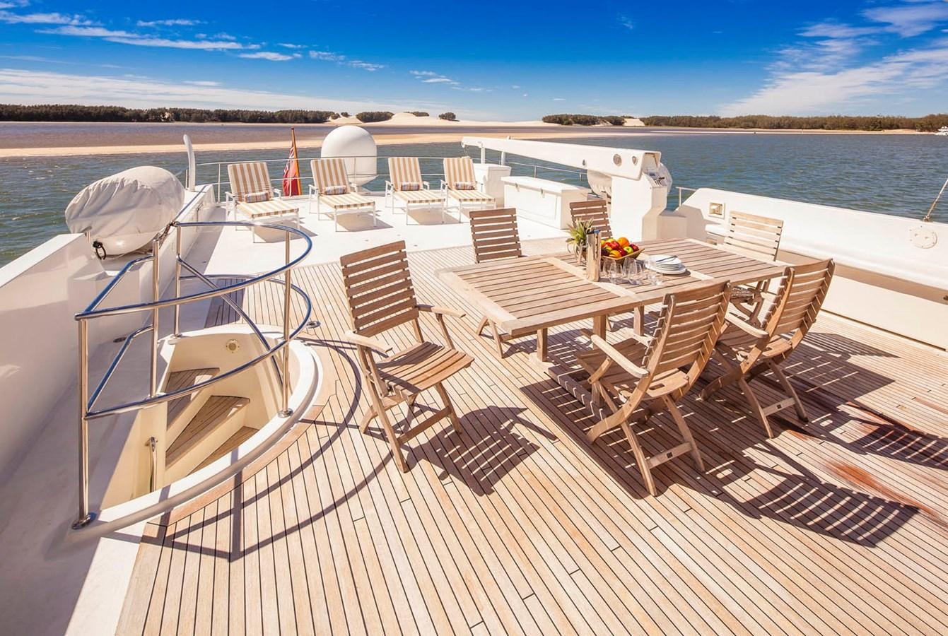 a deck with chairs and tables on it aboard SILENT WORLD II Yacht for Sale