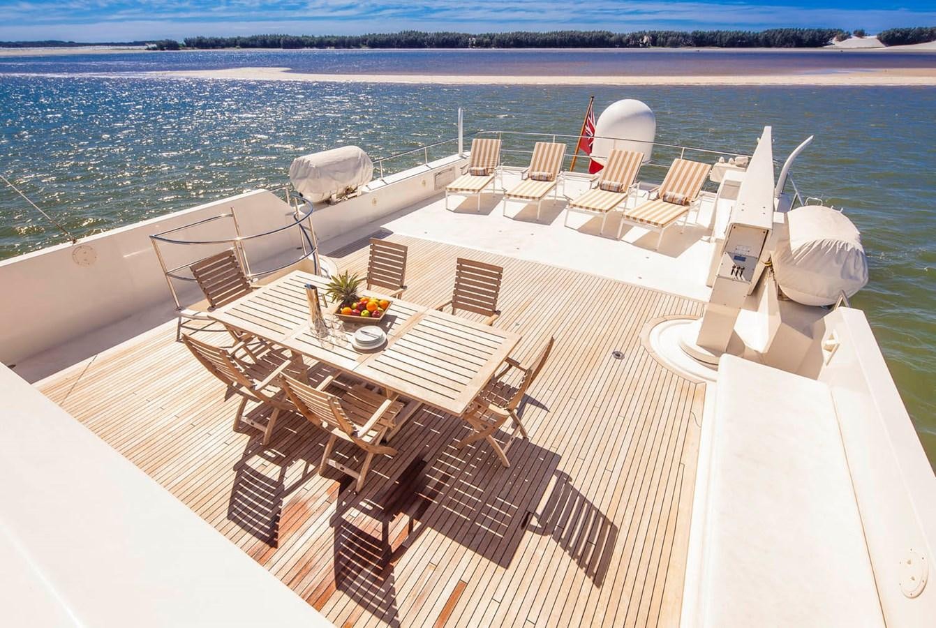 a deck with chairs and tables on it by the water aboard SILENT WORLD II Yacht for Sale
