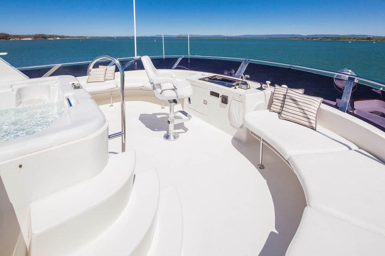 a white lounge chair on a white yacht on a white surface with blue water and a blue sky aboard SILENT WORLD II Yacht for Sale
