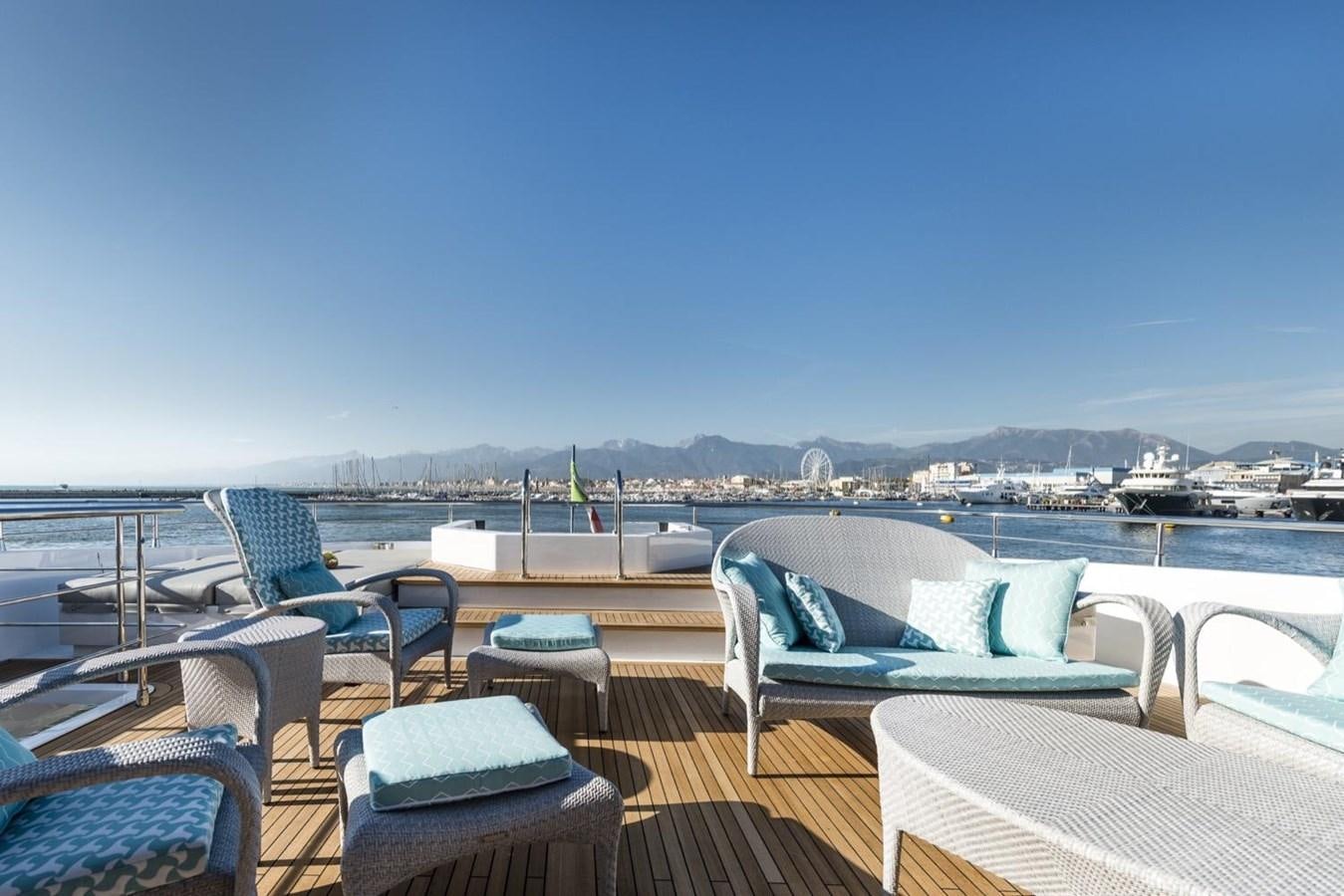 a deck with chairs and tables aboard HARMONY Yacht for Sale