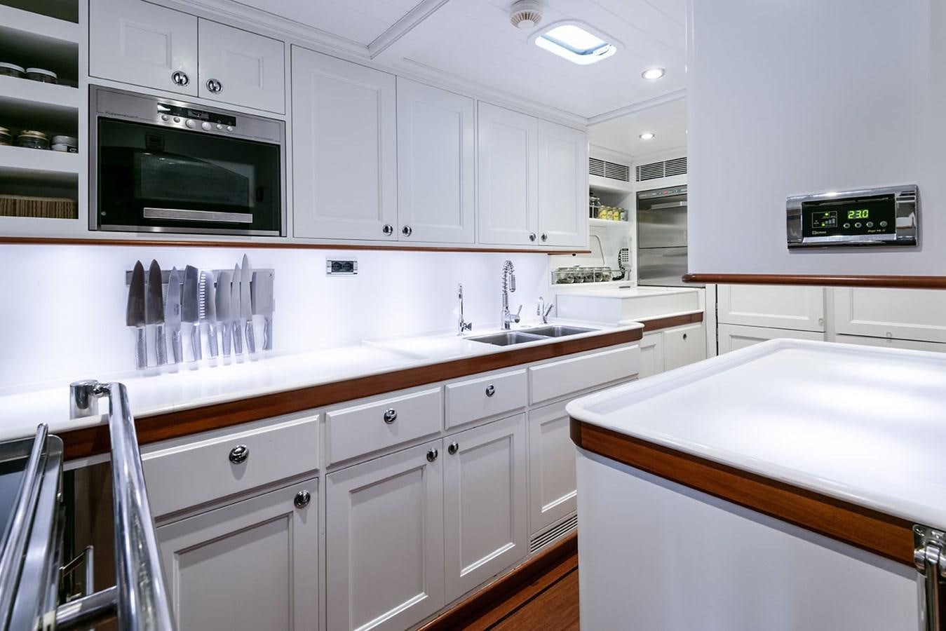 a kitchen with white cabinets aboard LA VICTORIA Yacht for Sale