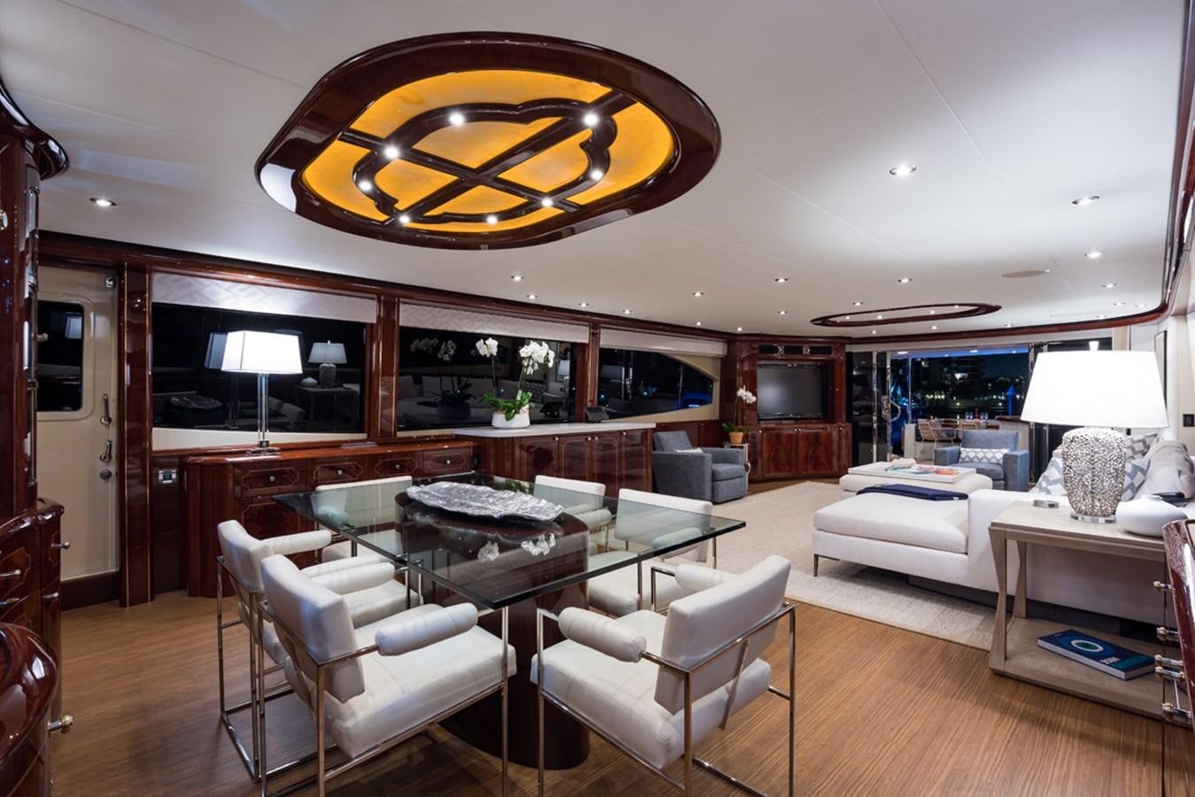 a large living room with a large chandelier aboard MONEY FOR NOTHING Yacht for Sale