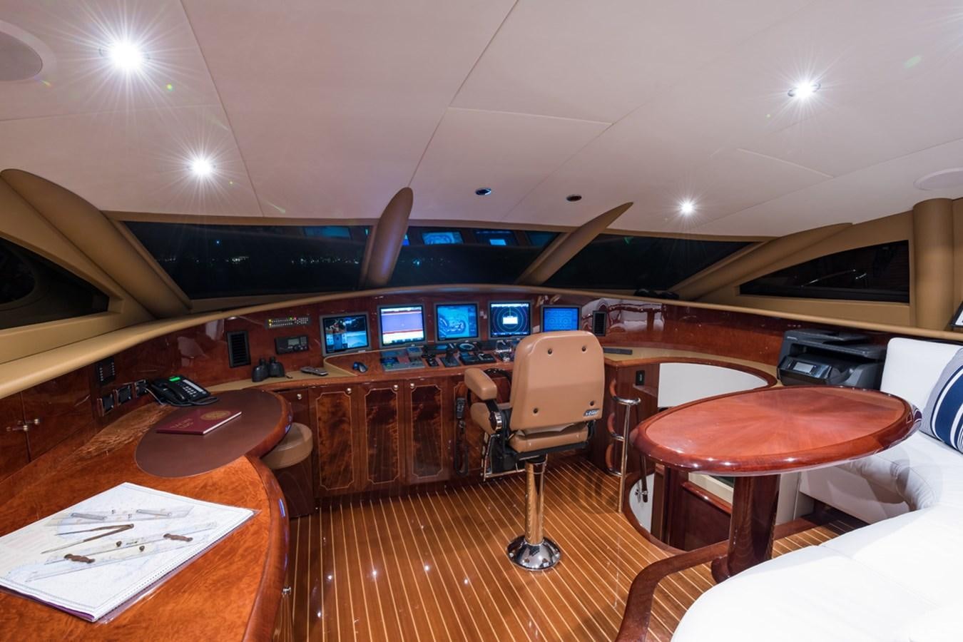 a room with a table chairs and a large window with a view of the city below aboard MONEY FOR NOTHING Yacht for Sale