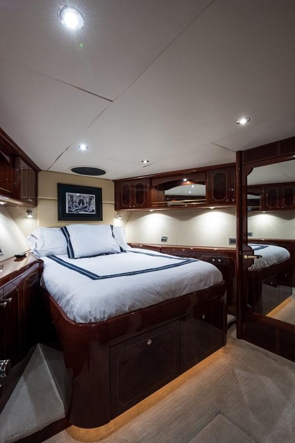 a bedroom with a bed and a mirror aboard MONEY FOR NOTHING Yacht for Sale