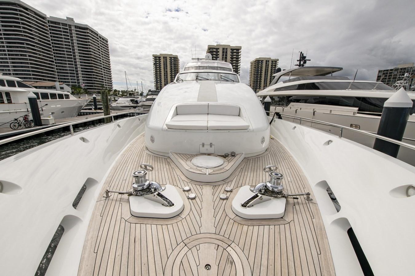 a deck with a boat and a large building in the background aboard MONEY FOR NOTHING Yacht for Sale