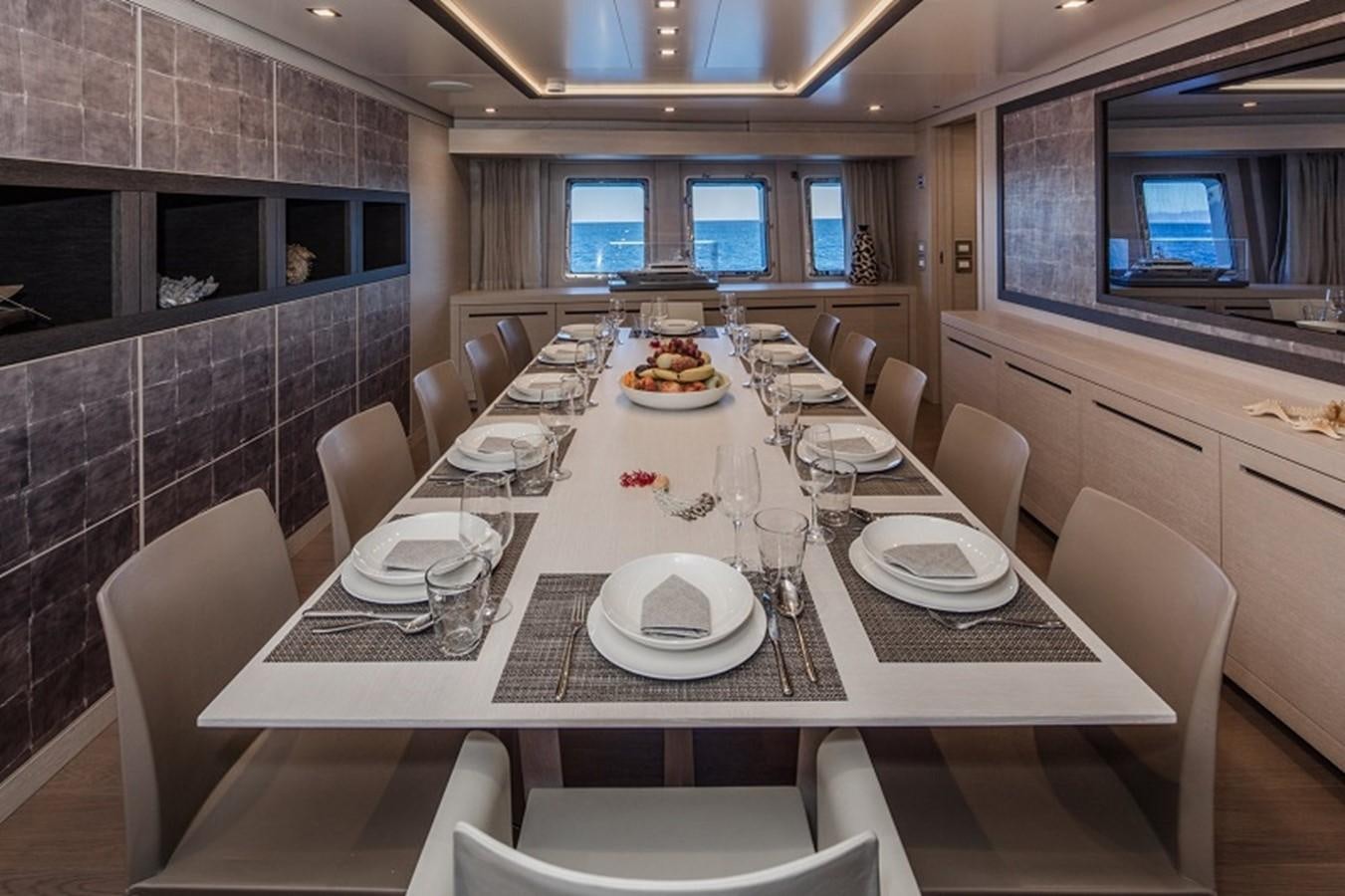 a large dining table with plates and chairs aboard OTAM SD35 Yacht for Sale