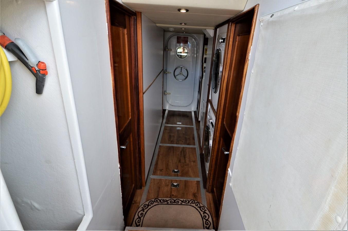 a hallway with a door and a clock on the wall aboard MISS STEPHANIE  Yacht for Sale