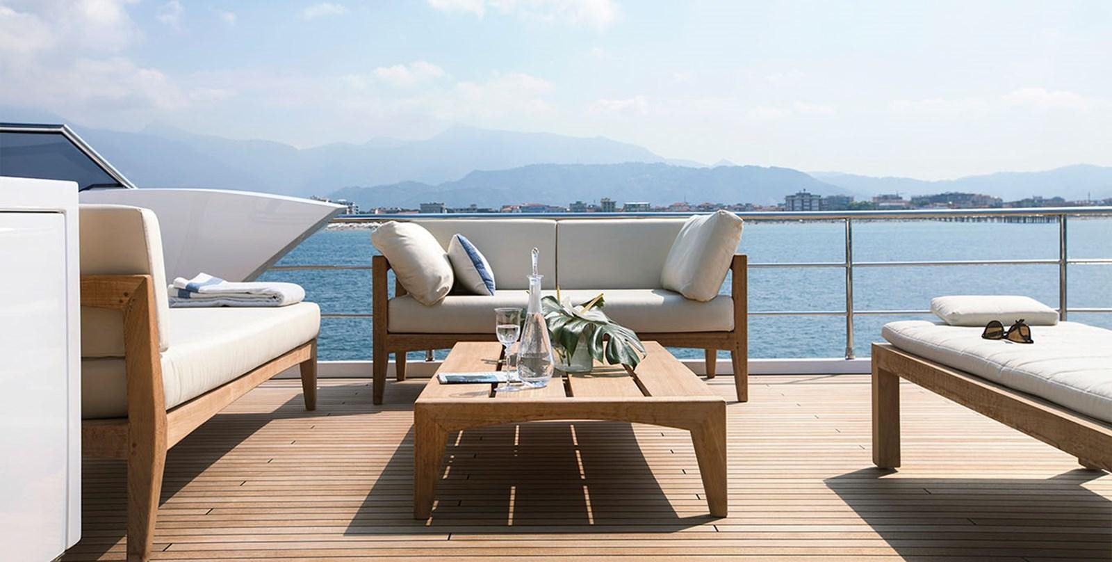 a table and chairs on a deck overlooking a body of water aboard VICIOUS RUMOUR II Yacht for Sale