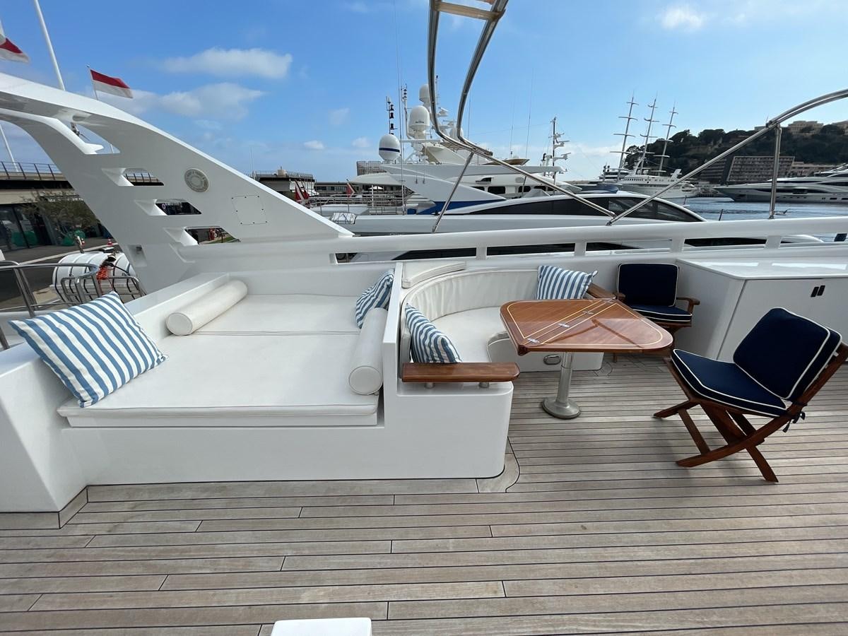 a deck with chairs and tables aboard GAUDEAMUS Yacht for Sale