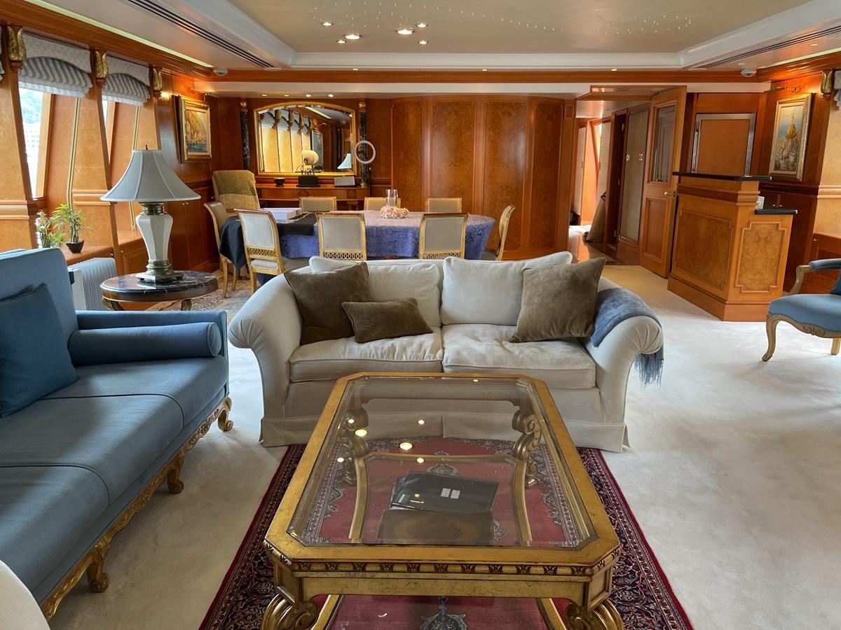 a living room with a large coffee table and a large window aboard GAUDEAMUS Yacht for Sale